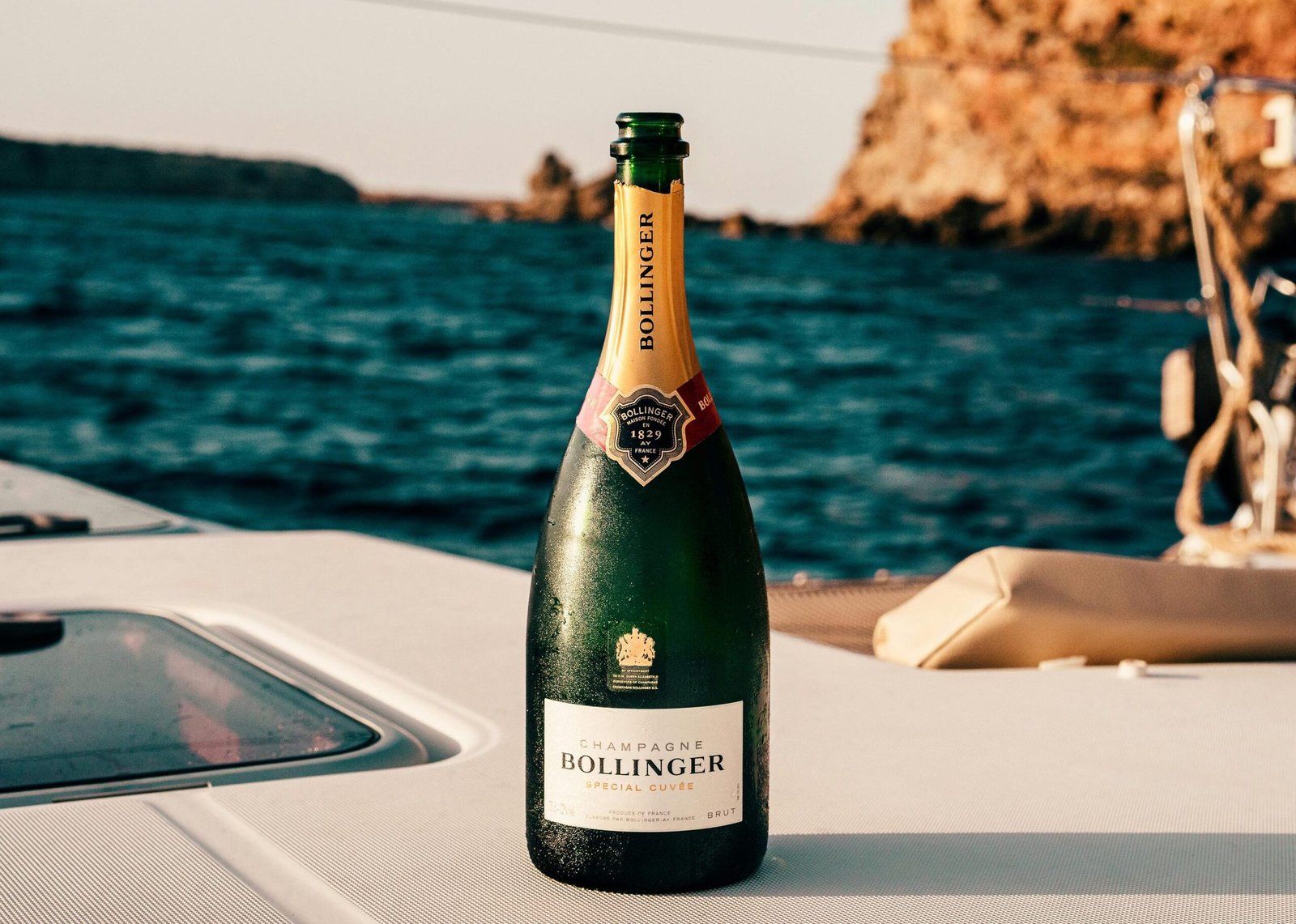 Bollinger champagne bottle on a yacht with Ibiza's ocean view, perfect for celebrations.